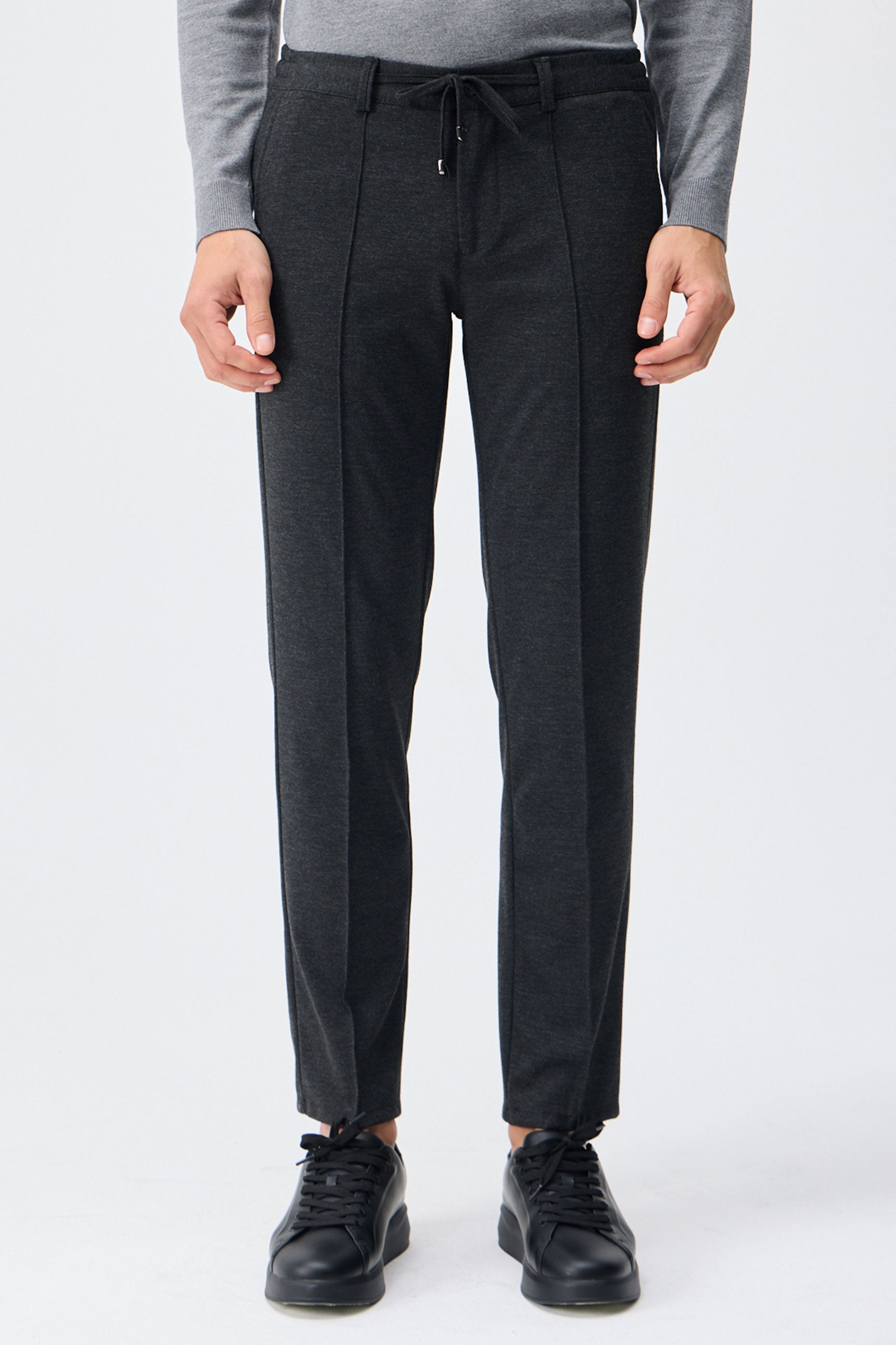 Herenpantalon met trekkoord in taupe- en antracietkleur, getailleerde pasvorm en taps toelopende pijpen.