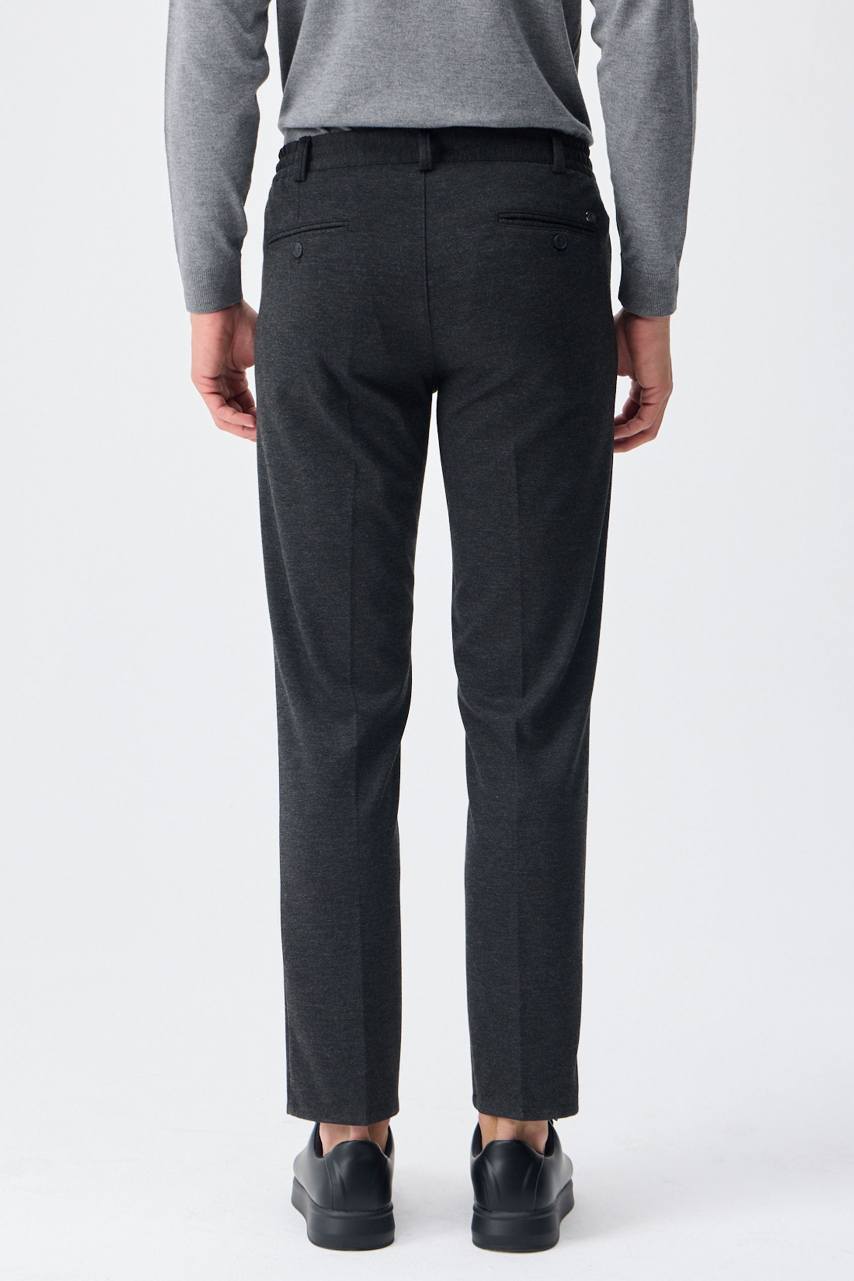 Herenpantalon met trekkoord in taupe- en antracietkleur, getailleerde pasvorm en taps toelopende pijpen.