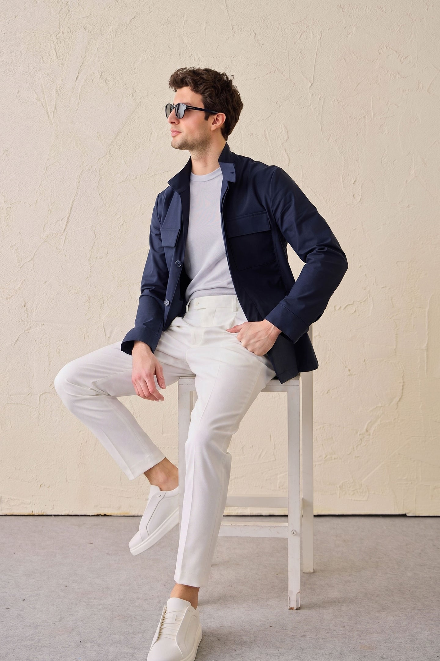 Heren safari-jas van marineblauwe katoenmix en witte broek, smart casual outfit