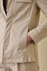 Beige smart casual tweedelig pak voor heren in safaristijl met opstaande kraag en stretchstof.