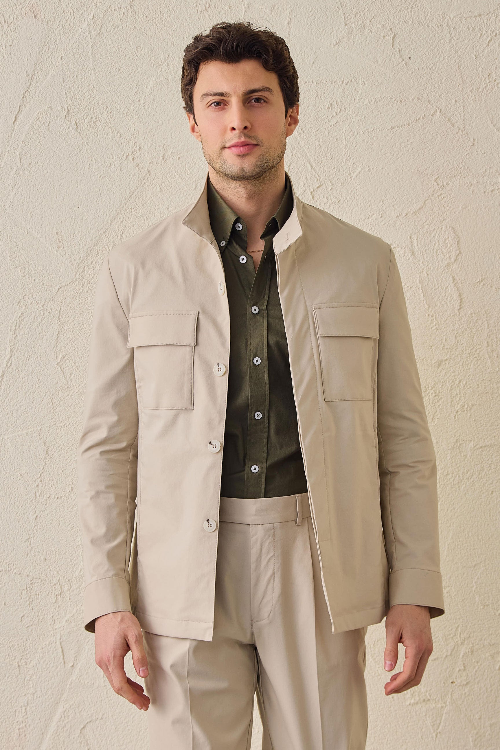 Beige smart casual tweedelig pak voor heren in safaristijl met opstaande kraag en stretchstof.