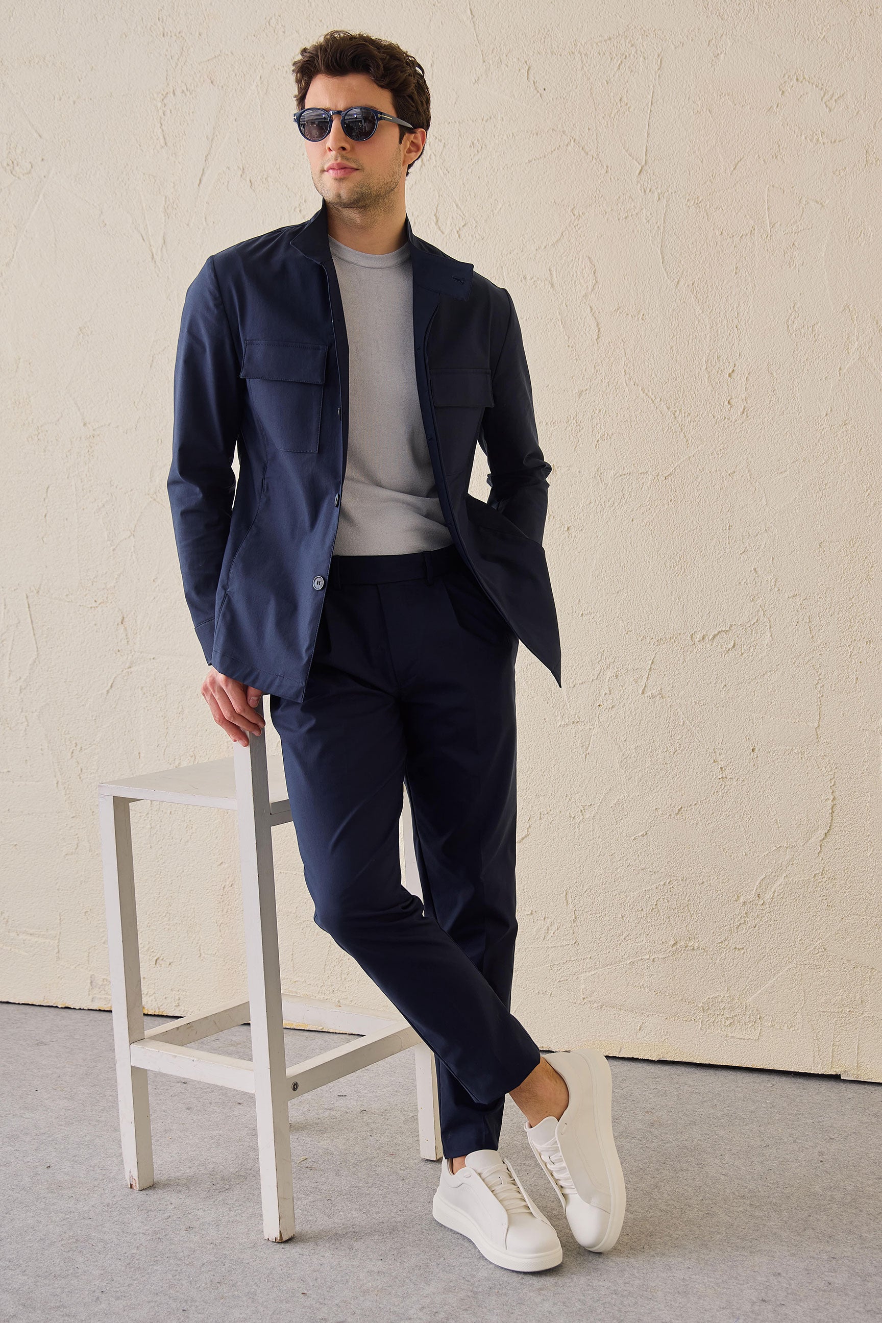 Marineblauwe smart casual tweedelige pak in safaristijl met opstaande kraag, stretchstof.
